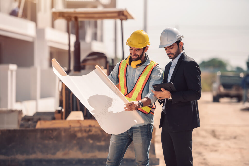 Servicios ingeniero civil y gerente de trabajadores de la construccion con tableta digital y planos hablando y planeando sobre el sitio de construccion concepto de trabajo en equipo de cooperacion (1)